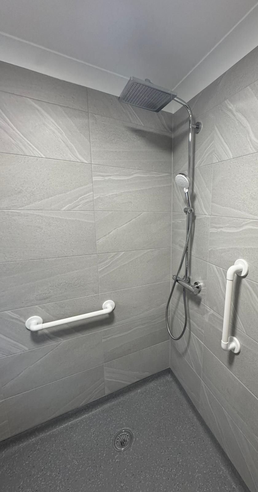 Level-access shower with grab rails and anti-slip flooring