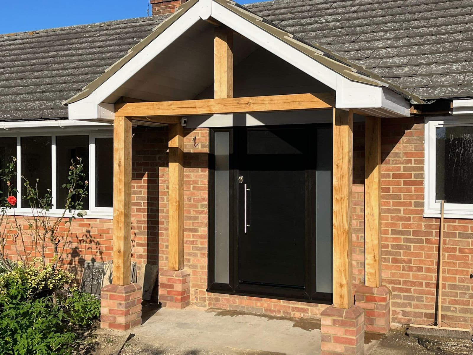 Oak-framed porch with a black front door, built by Coyne Build