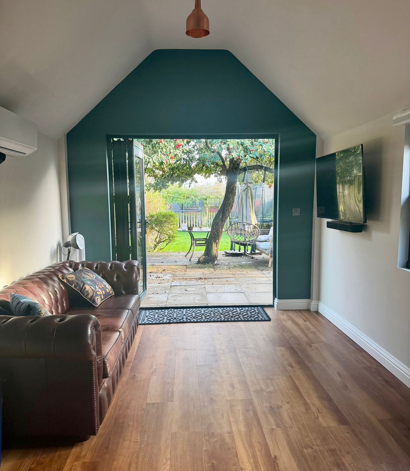 Vaulted rear extension living room with bifold doors and a feature wall