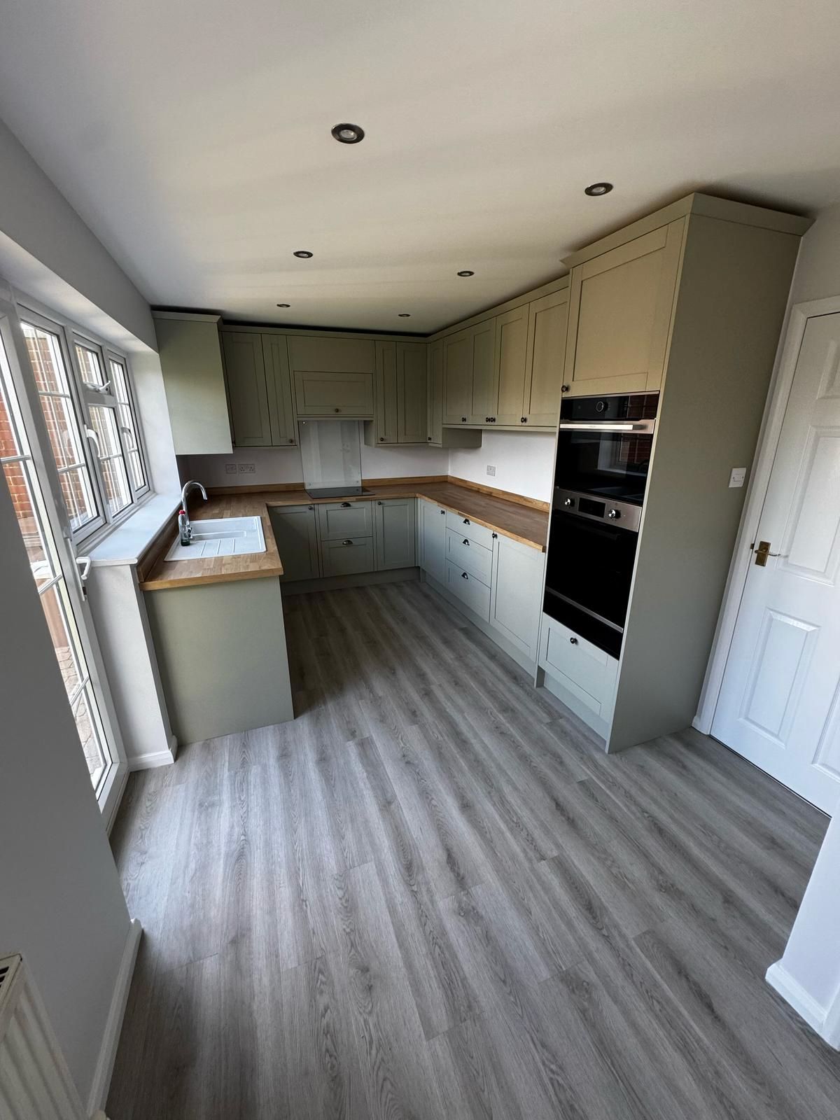 Grey wood-effect plank flooring in a fitted kitchen