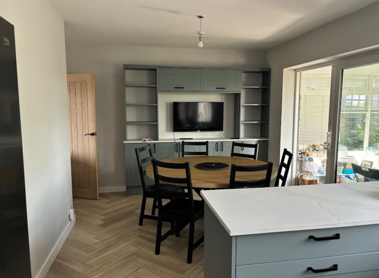 Kitchen-diner with a bespoke media dresser, round oak table and quartz island